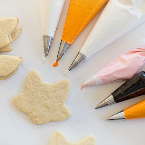 Decorating tools and icing set up for a cookie decorating party.